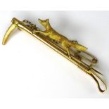 A Victorian 15ct gold fox stock pin, modelled with a running fox above a hunting crop, 7.3g, in