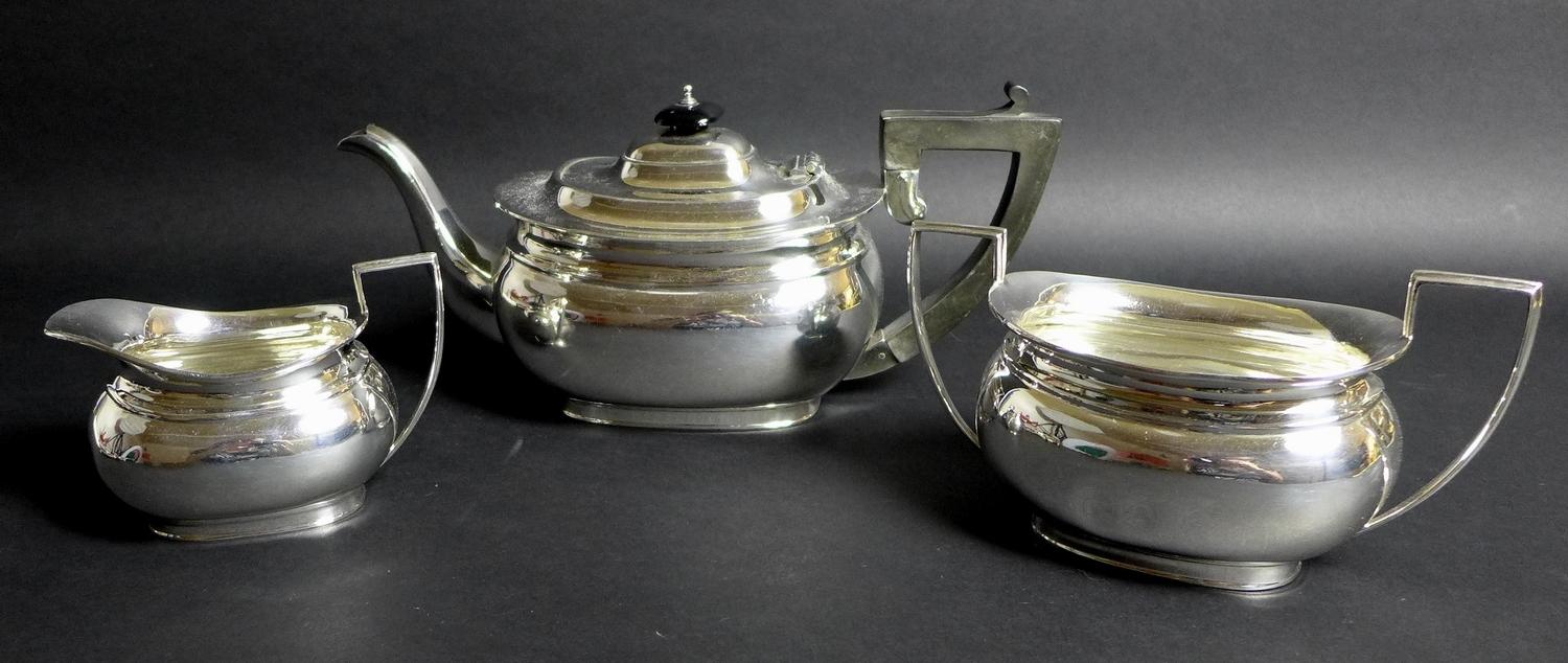 A George V silver three piece tea service, London shape, comprising teapot, twin handled sugar bowl,