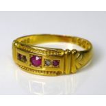 A Victorian 18ct gold ring set with a ruby flanked by one smaller diamond and two smaller rubies,