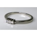 A platinum and diamond ring set with three princess cut stones, 0.15ct total, size N, 2.8g.