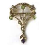 An Edwardian Art Nouveau suffragette brooch set with seed pearls, peridot and amethyst, 4 by 2.8cm.