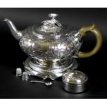 A George III silver teapot, decorated in Rococo style with repousse foliate and floral scrolls,