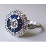 An 18ct white gold, diamond and sapphire ring, of Art Deco style circular design, the central