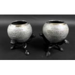 A pair of early 20th century Indian white metal spherical bowls with profuse foliate engraving, on