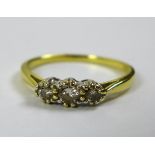 An 18ct gold three stone diamond ring, size O/P, central stone of approximately 0.13ct, 3.35mm