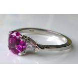An 18ct white gold, pink sapphire and diamond dress ring, the central sapphire of approximately 1.