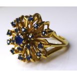 A 14ct gold and sapphire dress ring, the central round cut stone surrounded by eighteen smaller