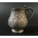 An Indian white metal cup, of baluster form, intricately decorated with flowers and foliage, with