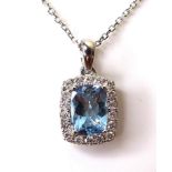 An 18ct white gold, aquamarine and diamond pendant, the central cushion cut aquamarine of