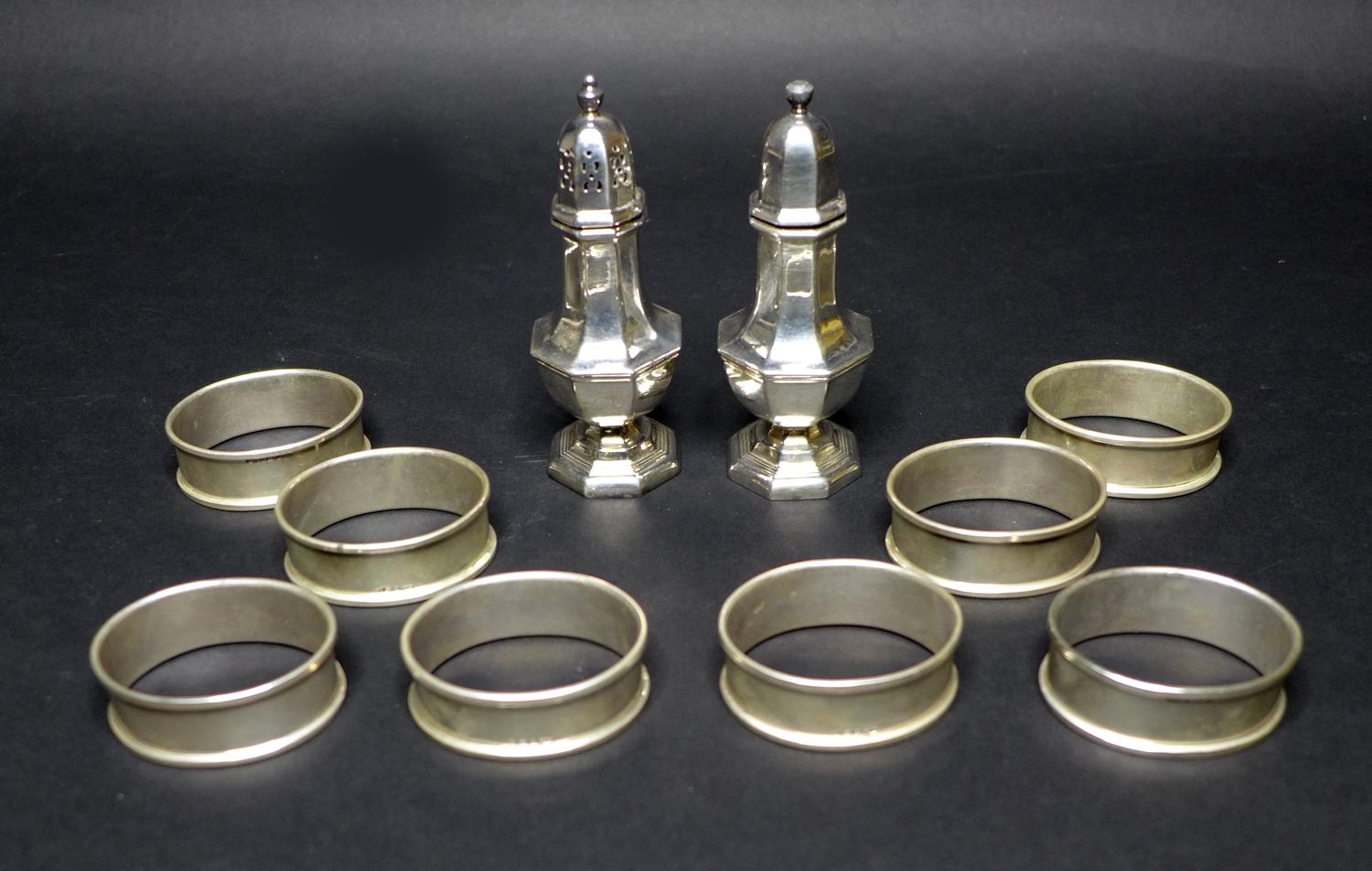 A silver salt and a silver pepper pot together with eight napkin rings, Birmingham 1991, with
