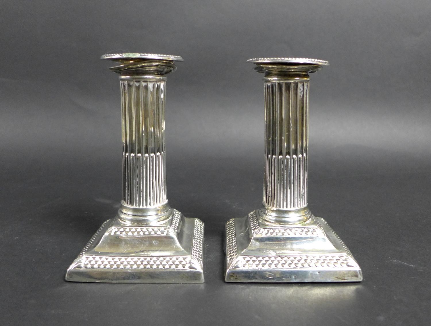 A pair of late Victorian silver dwarf candlesticks, of Roman Doric column form, with square plinths,