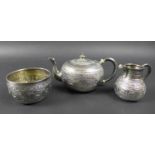 A Victorian silver three piece tea service, decorated after Indian Mughal style and embossed with