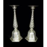 A pair of early 20th century Southern Indian silver candlesticks, the wide drip trays engraved
