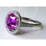An impressive, 18ct white gold, pink sapphire and diamond dress ring, the large oval cut deep rose