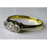 An 18ct gold and platinum three stone diamond ring, illusion set, central stone 0.1ct, size N, 2.3g.