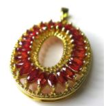 A 9ct gold and sunset ruby oval pendant, set with twenty four marquise cut rubies, each