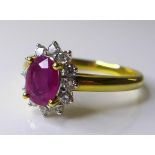 An 18ct gold, ruby and diamond ring, the oval cut ruby, of approximately 0.75ct, 7 by 5.04mm