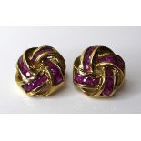 A pair of 9ct gold ruby knot form earrings, set with twelve oval brilliant cut rubies, London import