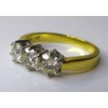 An 18ct gold and diamond three stone ring, each stone approximately 5mm diameter, total diamond