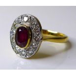 An 18ct gold, ruby and diamond dress ring, the central oval cut stone of approximately 0.75ct, 6.