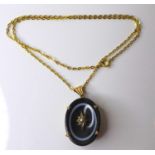 A 19th century French mourning pendant of black bull's eye agate set with a central seed pearl in