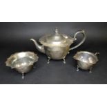 An Edwardian silver three piece tea set, comprising a squat form teapot with ebonised finial and