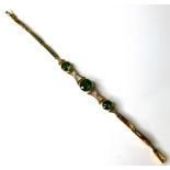 An Edwardian 15ct gold, green stone and diamond bracelet, composed of three brilliant cut stones,