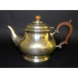 A George V silver teapot, of squat circular form, with ebonised handle and walnut finial, Adie Bros,