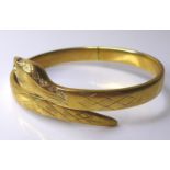 A 9ct gold snake form hinged bangle, with red stone eyes, 20.1g, 6.4cm internal width.