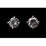 A pair of platinum and diamond stud earrings, each set with a single exceptionally white and clear