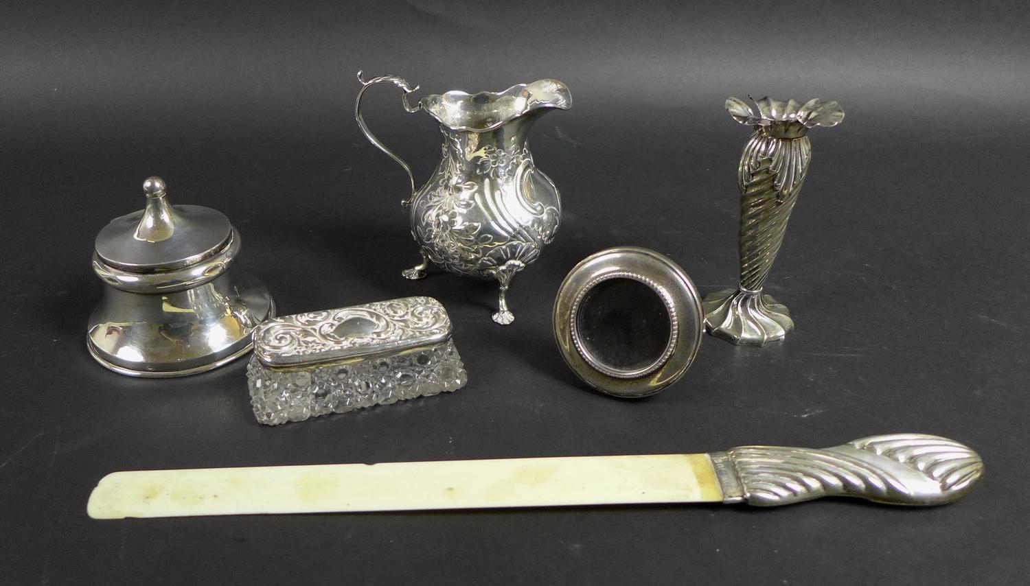 A group of five silver items, comprising a Victorian milk jug with repousse decoration and C