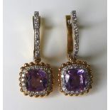 A pair of 18ct white and rose gold, amethyst and diamond earrings, with central cushion cut