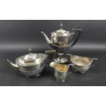 An Edwardian silver four piece tea and coffee service, of pedestal form with half reeded bodies,