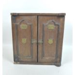 A late Victorian smoker's cabinet, in the form of a safe with brass plaques to the twin doors, one