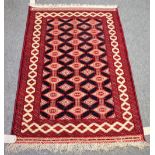 An Indian rug of Turkman design, the black field with three columns of connecting diamonds,