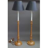 A pair of fruitwood carved table lamps with barley twist stems and a circular foot with black