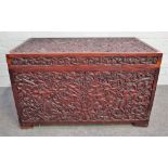 A 19th century Indian teak rectangular lift top trunk with profusely carved decoration,