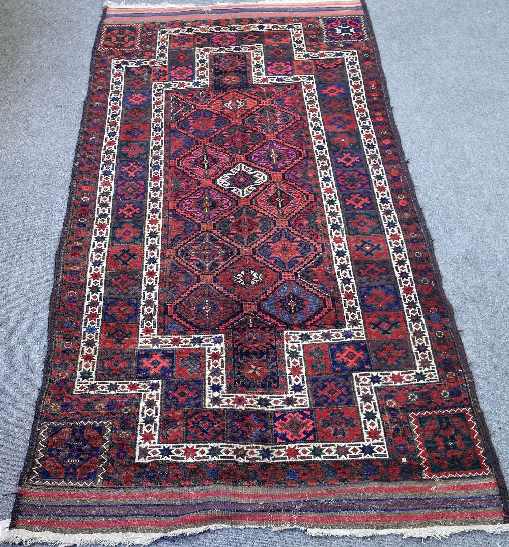 A Persian tribal rug with multicoloured repeating gul design within stepped white borders,