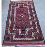 A Persian tribal rug with multicoloured repeating gul design within stepped white borders,
