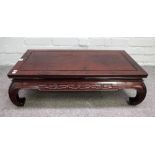 A 20th century Chinese hardwood low table, with carved frieze on inswept supports,