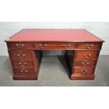 A diminutive mahogany nine drawer pedestal desk of 18th century style, 103cm wide x 61cm deep.