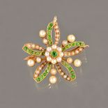 A gold, demantoid garnet and seed pearl set pendant brooch, in a curved cinquefoil design,