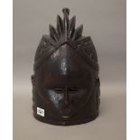 A West African Mende tribe 'Sowei' carved wooden helmet mask, black patina with ridged coiffure,