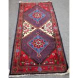 A Sonchor rug, Persian, the field with two indigo diamonds centred by a large flowerhead,