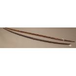 A hardwood and leather bound bow (141cm), possibly New Guinea and a bamboo bow (135cm),