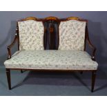 An Edwardian mahogany and marquetry inlaid two seater sofa with button back upholstery on tapering