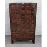 An early 20th century Chinese elm thirty two drawer apothecary chest on block feet,