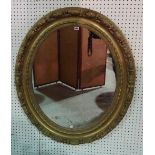 An early 19th century French gilt framed oval mirror, with floral leaf decoration,