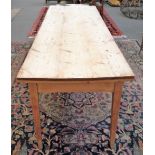 An early 19th century pine plank top kitchen table with frieze drawer on tapering square supports,