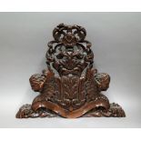 A 19th century Continental walnut finial carved as opposing winged angles, surmounted by a lurcher,